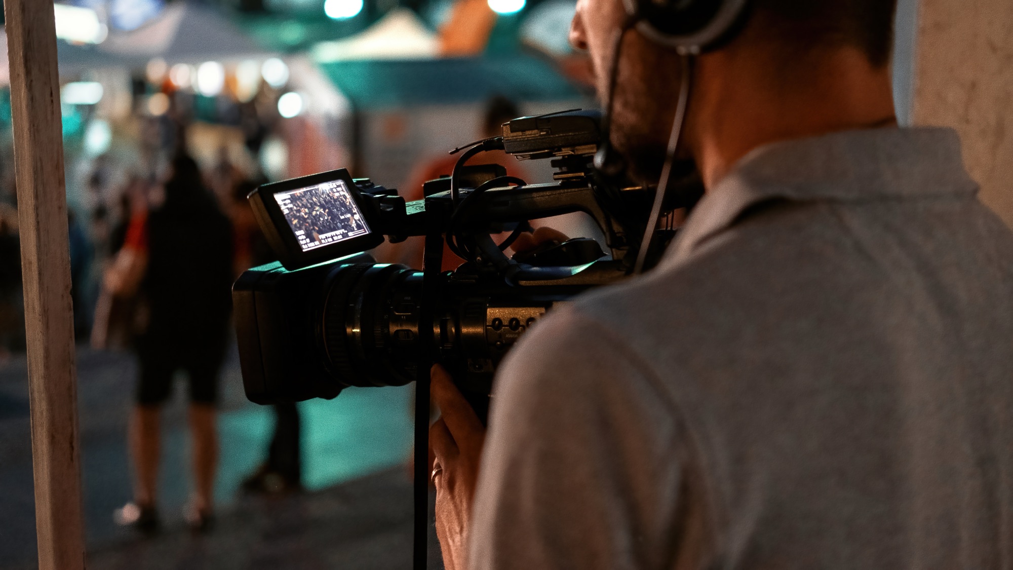 Camera operator recording a crowd at night